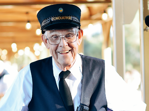 A smiling man in a conductor uniform