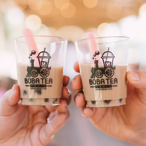 Two people toast with glasses of boba tea