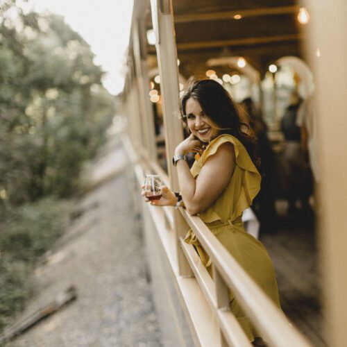Woman leaning against the rail of train car
