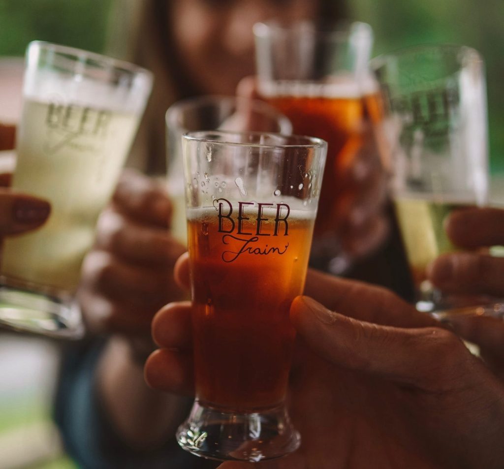 Group toasting with various glasses of beer.